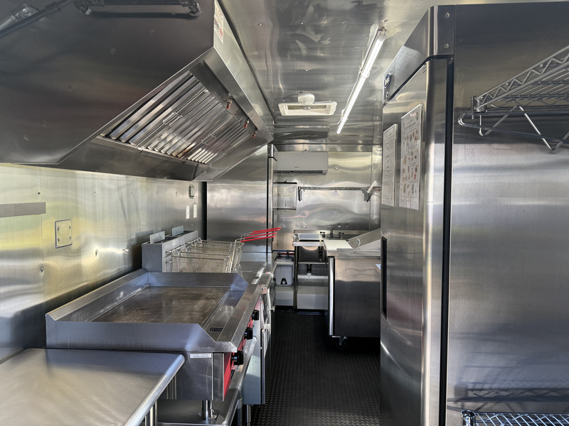 Food trailer interior kitchen with stainless steel walls and commercial equipment