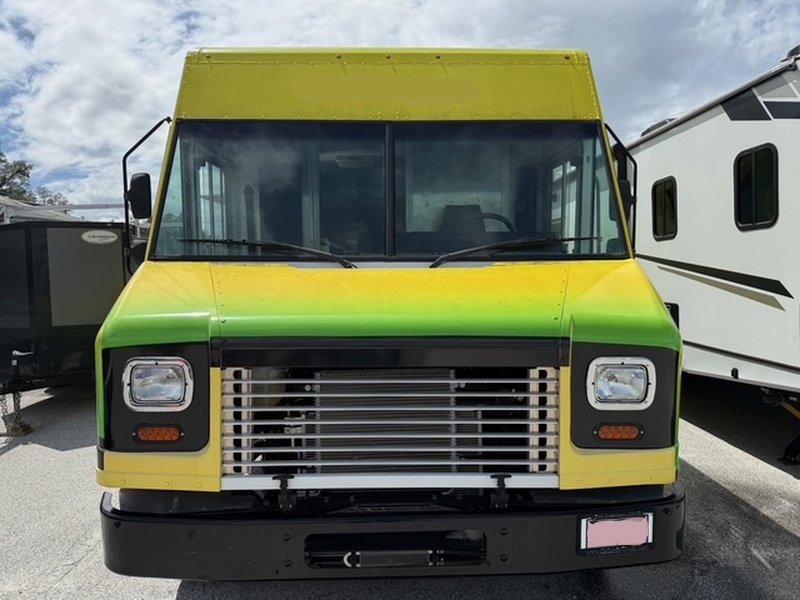 Front exterior view of a 2022 Ford F59 food truck for sale in Pasco County Florida with yellow and green wrap