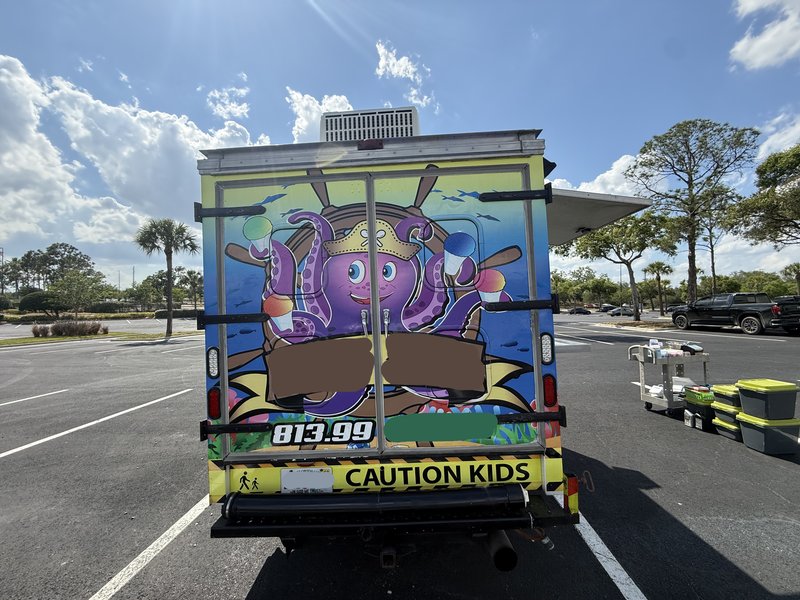 Rear exterior of a shaved ice truck for sale in Florida — back end of the 1997 Chevrolet Express 3500 with custom graphics